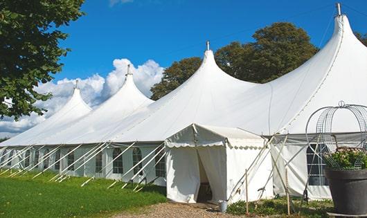 tall green portable restrooms assembled at a music festival, contributing to an organized and sanitary environment for guests in Valrico